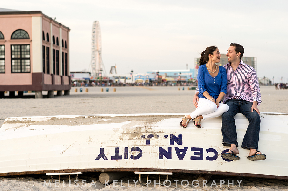 Ocean City engagement photo on beach with lifeguard boat.